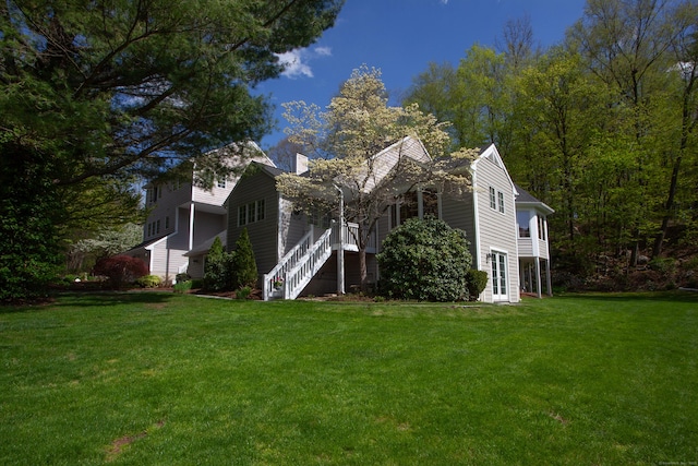view of home's exterior with a chimney and a lawn