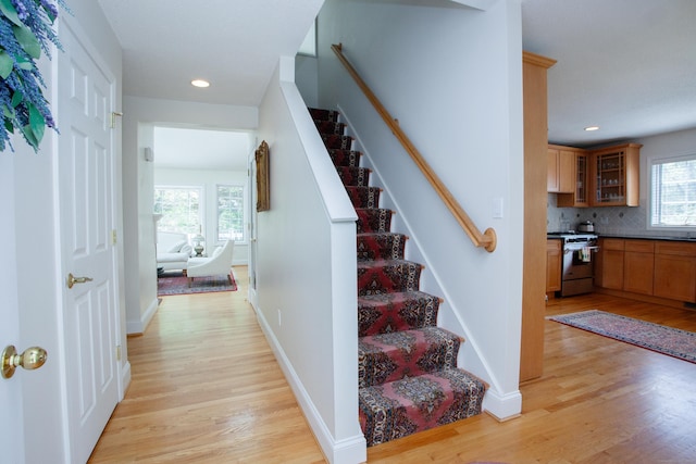 staircase with recessed lighting, baseboards, and wood finished floors