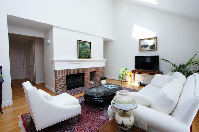 living area featuring baseboards, a fireplace, and wood finished floors