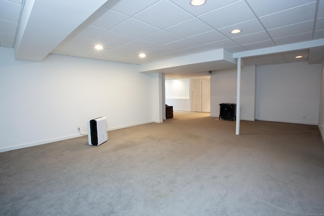 finished basement with a paneled ceiling, carpet, baseboards, and recessed lighting
