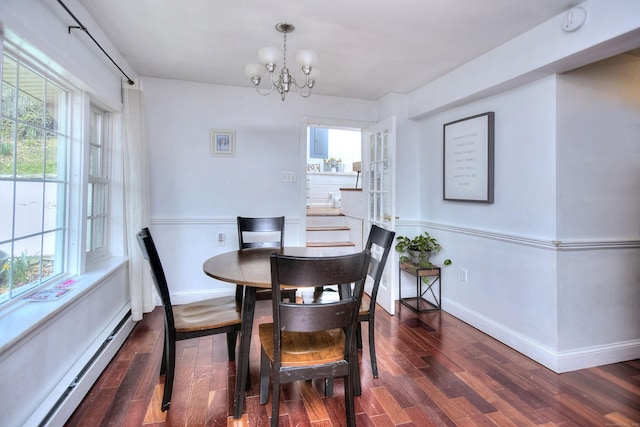 dining area featuring baseboard heating, a chandelier, wood finished floors, baseboards, and plenty of natural light
