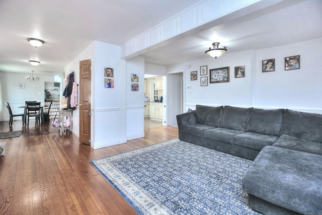 living room featuring wood-type flooring and a chandelier