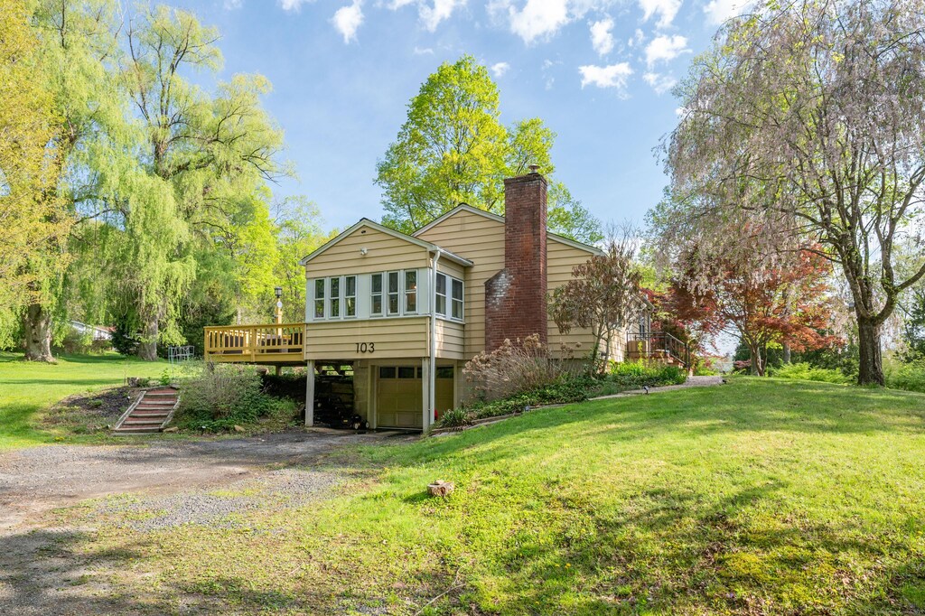 103 Squash Hollow Rd, New Milford, CT 06776 - rear view of house featuring dirt driveway, a chimney, a carport, a wooden deck, and a lawn