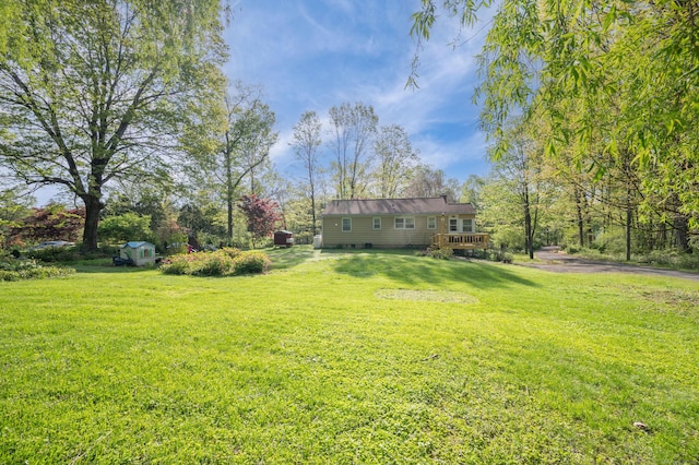 view of grassy yard featuring a deck