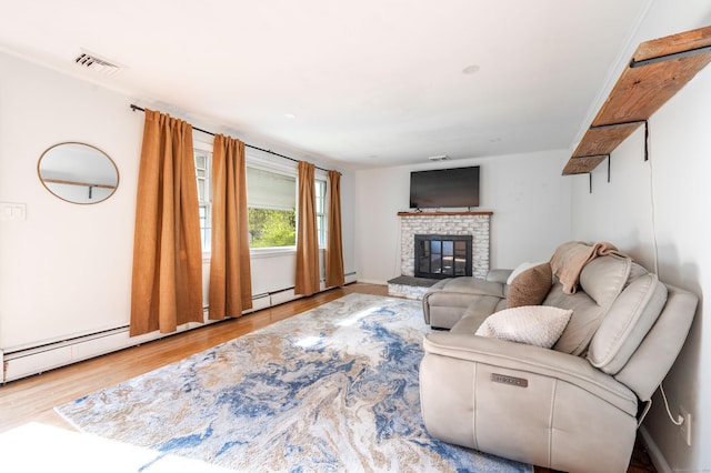 living room with a baseboard heating unit, wood finished floors, and a fireplace