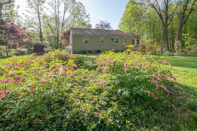 rear view of house with a deck, crawl space, and a yard
