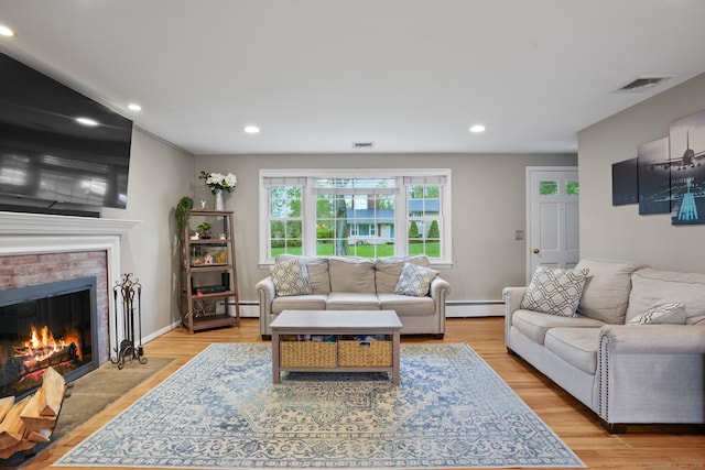 living area with recessed lighting, a brick fireplace, visible vents, and a baseboard heating unit
