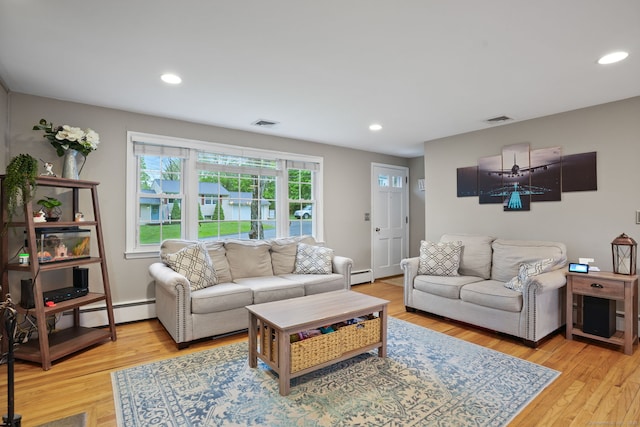 living area with a baseboard heating unit, recessed lighting, light wood-style flooring, and visible vents
