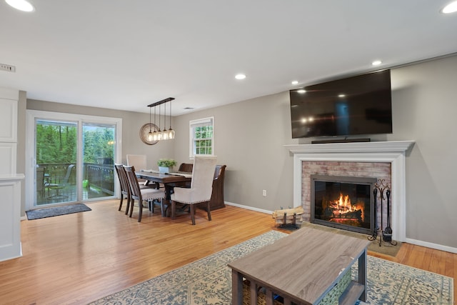 living room featuring light wood-style floors, a fireplace, and recessed lighting