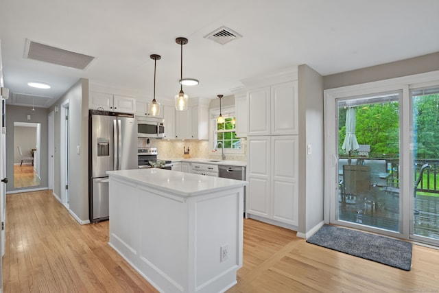 kitchen with a sink, stainless steel appliances, light wood-style flooring, and visible vents