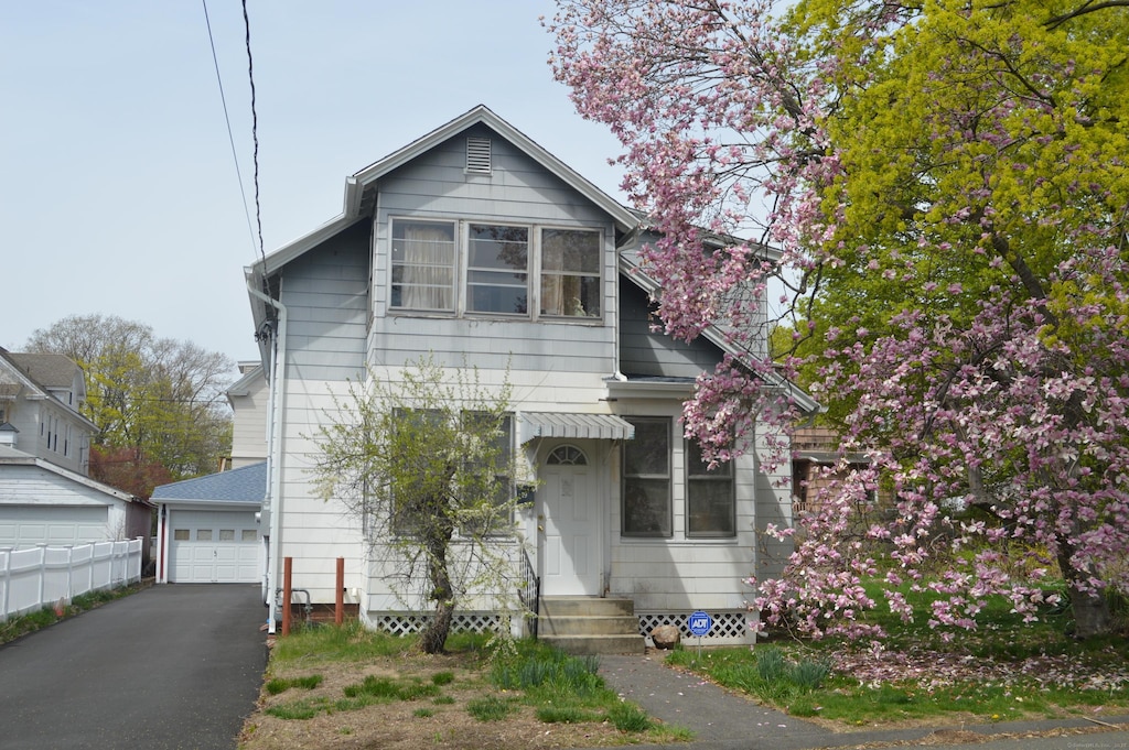view of front facade with entry steps, fence, and a detached garage