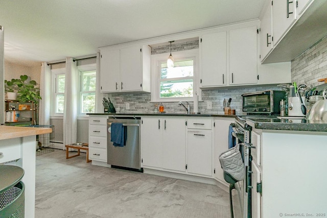 kitchen with appliances with stainless steel finishes, decorative backsplash, dark countertops, and white cabinets