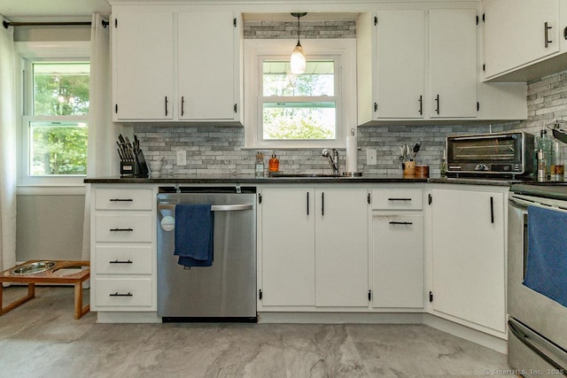 kitchen featuring appliances with stainless steel finishes, a sink, dark countertops, and healthy amount of natural light