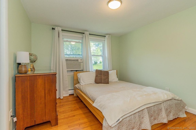 bedroom featuring light wood-style flooring and baseboard heating