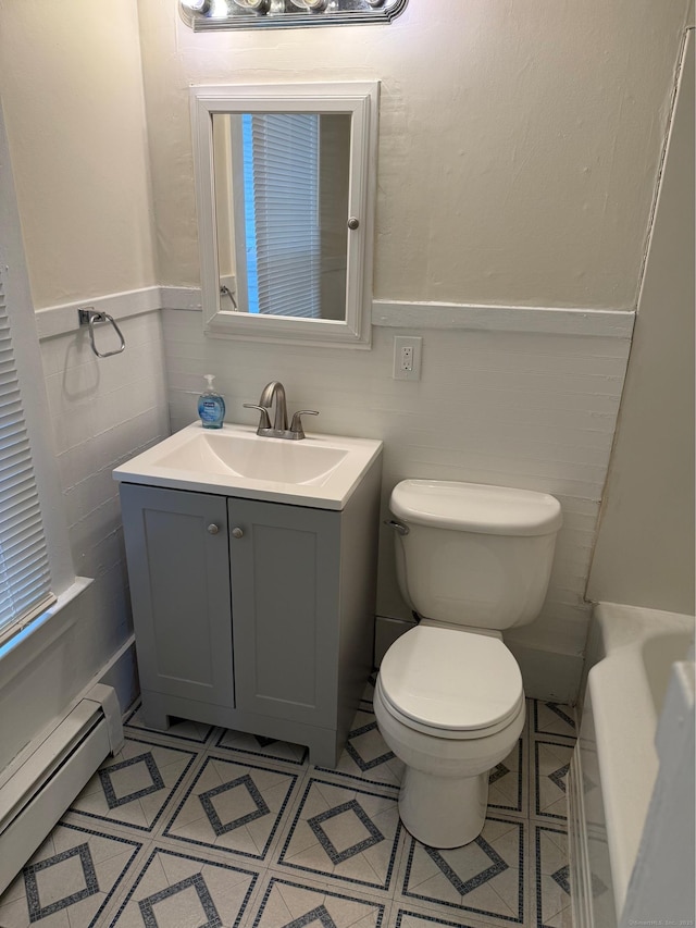 full bath with a bathtub, a baseboard heating unit, toilet, tile patterned flooring, and vanity