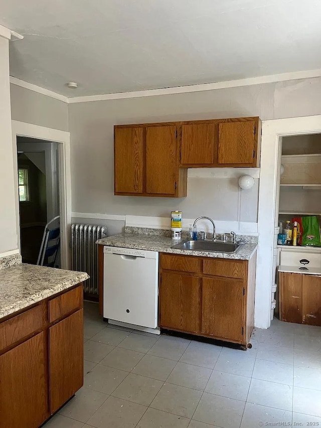 kitchen with brown cabinets, a sink, radiator, light countertops, and white dishwasher