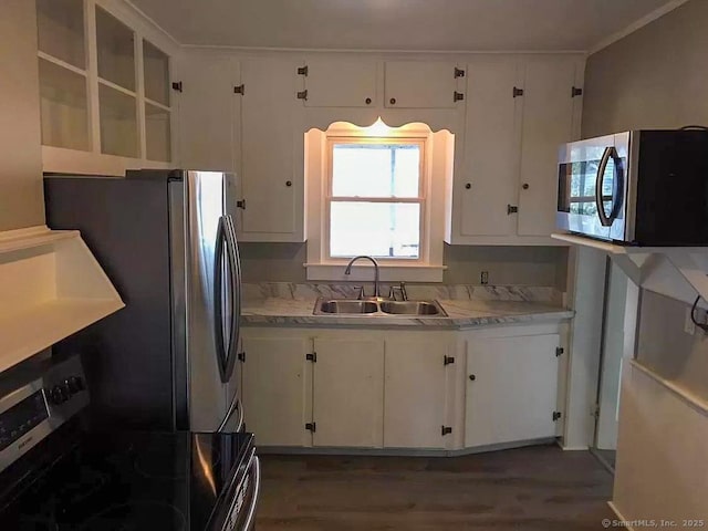 kitchen with wood finished floors, a sink, white cabinets, light countertops, and appliances with stainless steel finishes