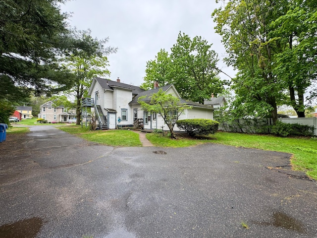 view of front of property with a chimney, a front yard, and fence