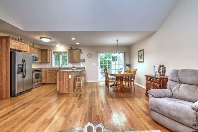 30 Prosperity Ct Unit 25, Southington, CT 06489 - kitchen with stainless steel appliances, open floor plan, light wood-style flooring, a kitchen breakfast bar, and baseboards