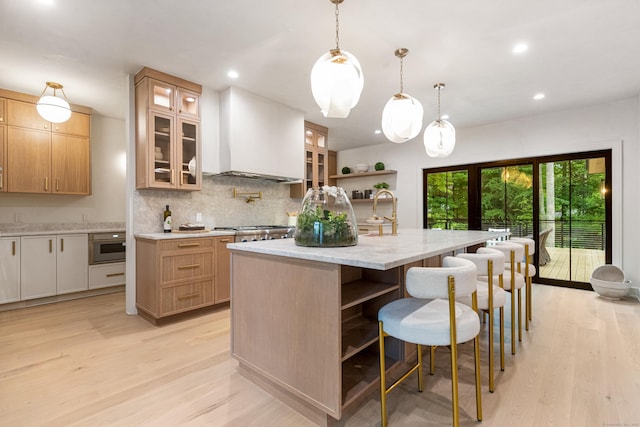 26 Hitchcock Rd, Westport, CT 06880 - kitchen featuring light wood-type flooring, tasteful backsplash, open shelves, a breakfast bar area, and recessed lighting