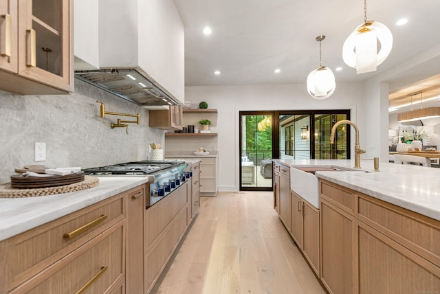 26 Hitchcock Rd, Westport, CT 06880 - kitchen with wall chimney range hood, a sink, stainless steel gas cooktop, light wood-type flooring, and backsplash