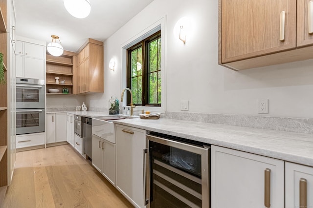 26 Hitchcock Rd, Westport, CT 06880 - kitchen with beverage cooler, appliances with stainless steel finishes, a sink, light countertops, and light wood-type flooring