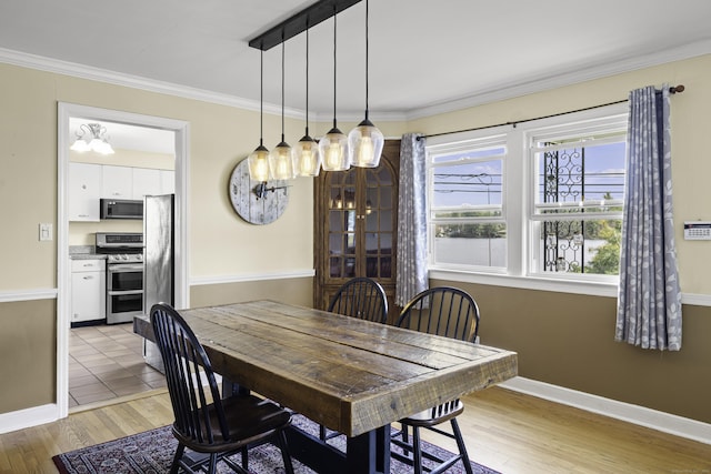 870 Lakeside Dr, Bridgeport, CT 06606 - dining space with light wood finished floors, crown molding, baseboards, and a chandelier