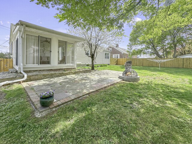 870 Lakeside Dr, Bridgeport, CT 06606 - rear view of property featuring a fenced backyard, an outdoor fire pit, a patio, and a lawn
