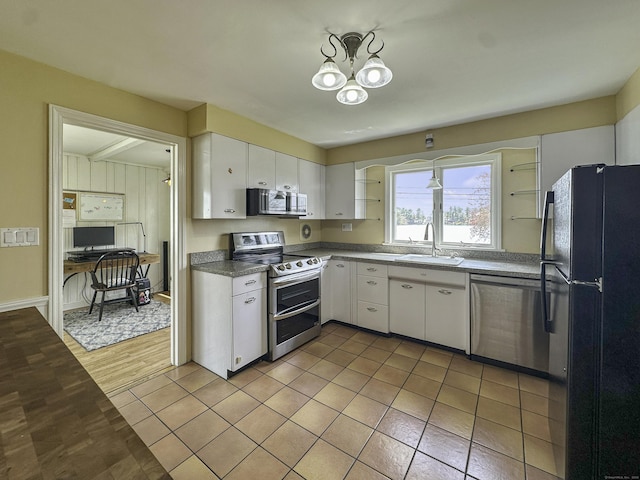 870 Lakeside Dr, Bridgeport, CT 06606 - kitchen with a sink, an inviting chandelier, stainless steel appliances, and white cabinetry
