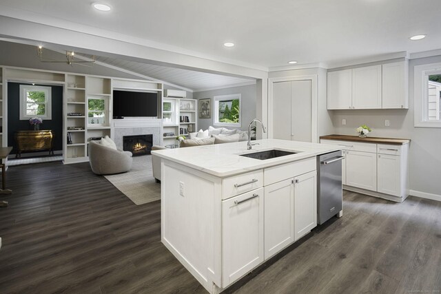 kitchen featuring a sink, lofted ceiling, dishwasher, dark wood-style floors, and a lit fireplace