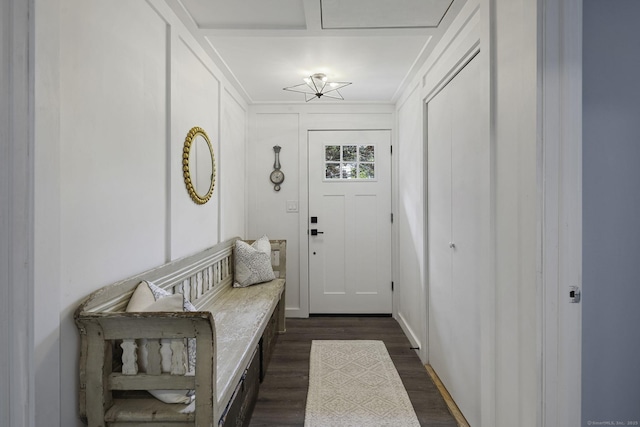 doorway with ornamental molding and dark wood-type flooring