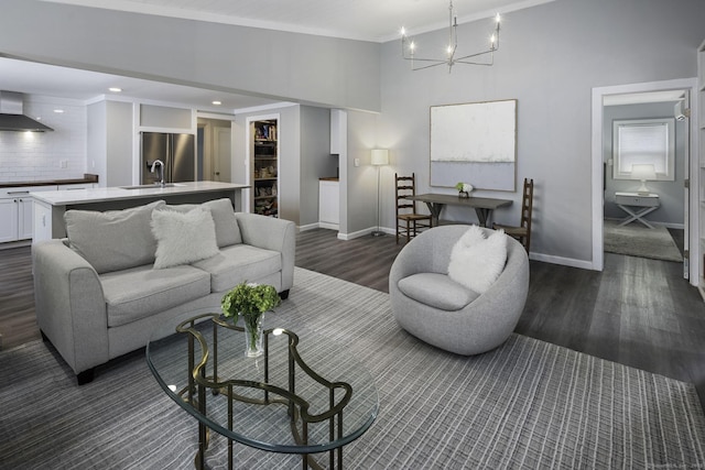 living area with dark wood-style floors, a chandelier, baseboards, crown molding, and recessed lighting