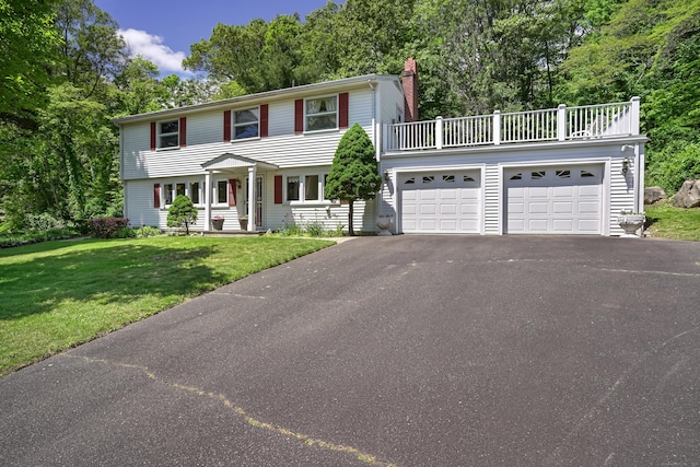 37 Shawnee Rd, Trumbull, CT 06611 - colonial home featuring asphalt driveway, a balcony, a chimney, a front yard, and an attached garage