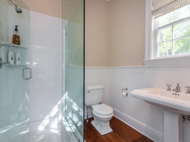 bathroom featuring a stall shower, wainscoting, toilet, wood finished floors, and baseboards