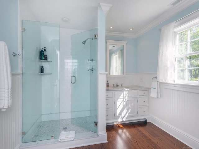 full bathroom featuring a wainscoted wall, a stall shower, wood finished floors, vanity, and crown molding