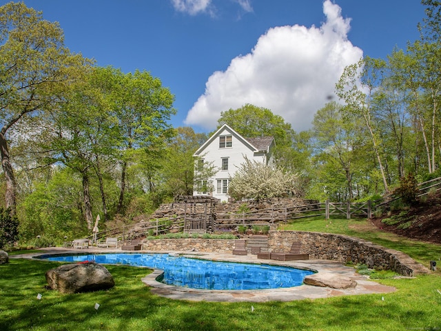 outdoor pool with a yard and a patio