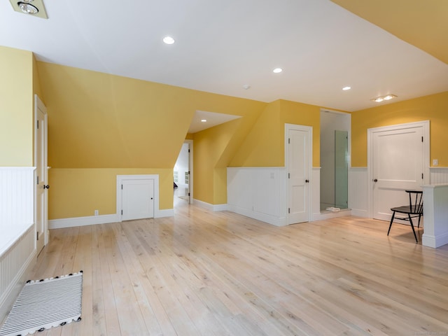 additional living space featuring light wood-type flooring, a wainscoted wall, and recessed lighting