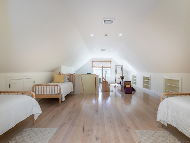 bedroom with light wood-type flooring and vaulted ceiling
