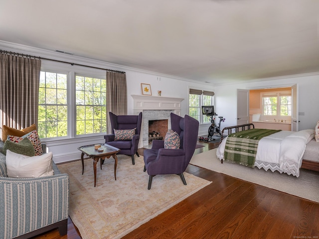 living room with crown molding, wood finished floors, and a fireplace