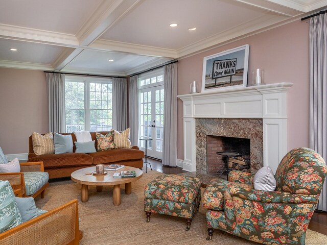 living area featuring ornamental molding, beam ceiling, a premium fireplace, recessed lighting, and baseboards