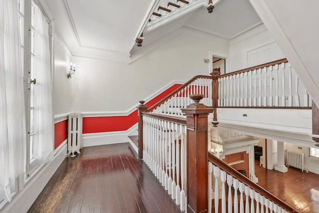 stairs featuring crown molding, wood-type flooring, and radiator heating unit