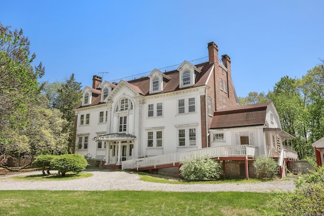 rear view of house with a chimney and a wooden deck