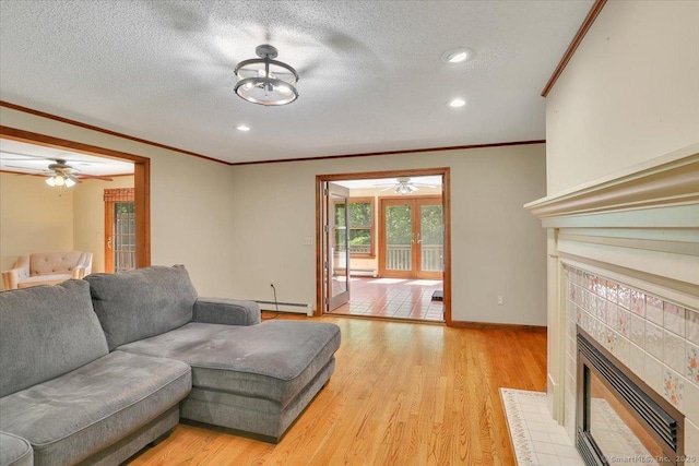 32 Powder Hill Rd, Middlefield, CT 06455 - living area featuring a ceiling fan, a tile fireplace, ornamental molding, light wood-style flooring, and a textured ceiling