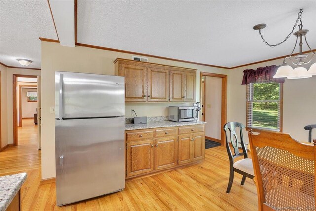 32 Powder Hill Rd, Middlefield, CT 06455 - kitchen with stainless steel appliances, light wood-style floors, ornamental molding, a textured ceiling, and brown cabinetry