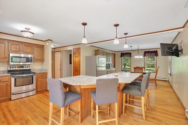 32 Powder Hill Rd, Middlefield, CT 06455 - kitchen featuring appliances with stainless steel finishes, light wood-style flooring, a kitchen island, a kitchen bar, and pendant lighting