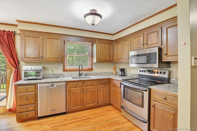 32 Powder Hill Rd, Middlefield, CT 06455 - kitchen featuring stainless steel appliances, a sink, crown molding, a textured ceiling, and light wood finished floors