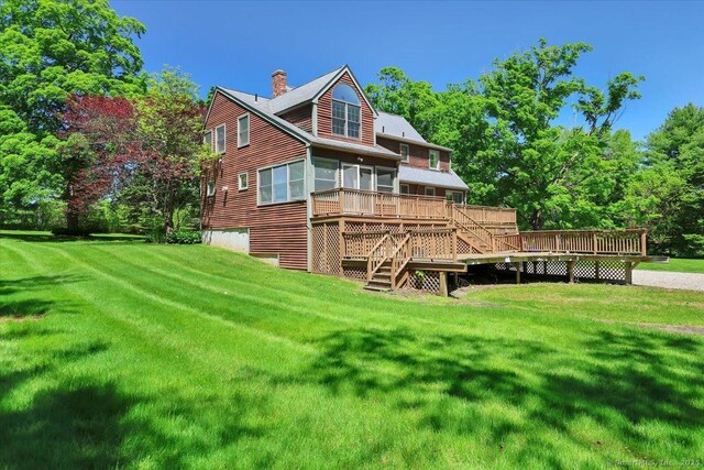 32 Powder Hill Rd, Middlefield, CT 06455 - back of house with a sunroom, stairs, a wooden deck, a chimney, and a yard