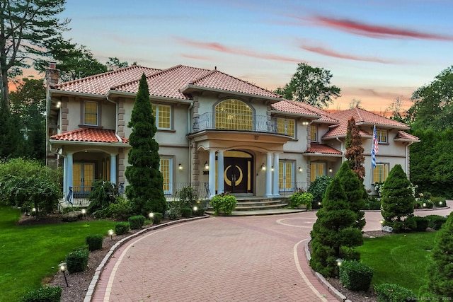 79 Comstock Hill Ave, Norwalk, CT 06850 - mediterranean / spanish-style home featuring a balcony, a tiled roof, french doors, a chimney, and stucco siding