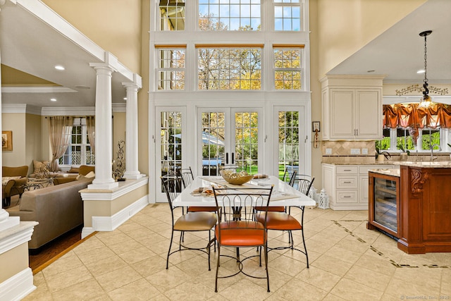 79 Comstock Hill Ave, Norwalk, CT 06850 - dining room with a high ceiling, ornate columns, wine cooler, plenty of natural light, and crown molding