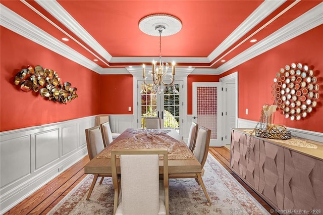 79 Comstock Hill Ave, Norwalk, CT 06850 - dining area featuring a chandelier, a tray ceiling, a decorative wall, hardwood / wood-style floors, and a wainscoted wall